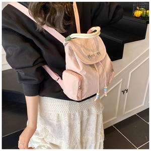 Detail eines rosa Nylonrucksacks mit MeaRey-Logo-Stickerei und Kordelzugverschluss