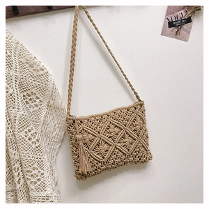 Détail du sac bandoulière bohème tissé avec pompon et texture en maille de losanges