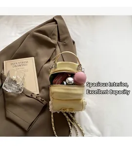 Detail of yellow heart lace backpack with metal chain strap and bow on white bedding