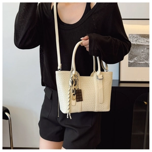 Détail du petit sac blanc texturé avec breloque chocolat et sangle à nœuds tressés