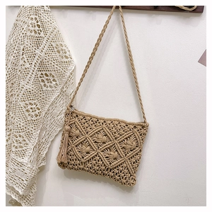 Détail du sac bandoulière bohème en macramé avec motifs losanges et pompons