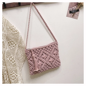 Détail du tissage macramé fait main et pompon rose sur le sac de plage bohème
