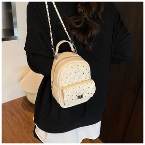 Detail of cream mini backpack featuring quilted diamond pattern with sparkling rhinestones