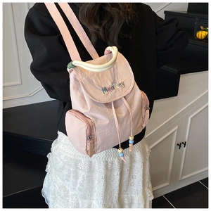 Detailansicht eines rosa Nylon-Rucksacks mit Kordelzug und seitlicher Reißverschlusstasche