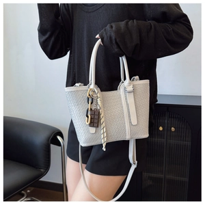 Détail de la texture crocodile, du panneau tissé et du foulard décoratif sur un sac gris