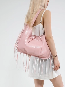 Pink niche tote bag with long leather fringe tassels and bow detail on model