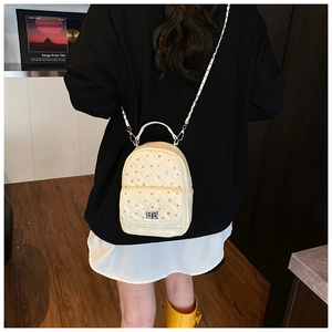 Detail of cream quilted mini backpack with sparkling rhinestones and silver chain straps