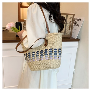 Détail d'un sac cabas en paille tressée avec dégradé violet et bandoulière en cuir