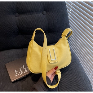Close-up of yellow hobo bag with lychee pattern leather and silver U-shaped metal buckle