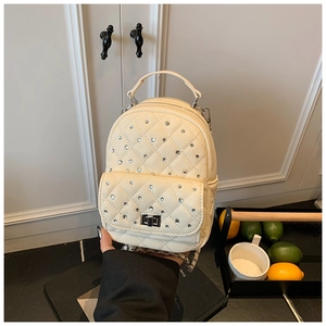 Detail shot of mini quilted backpack in cream PU leather with sparkling rhinestone accents