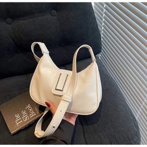 Detailed macro view of white textured leather and silver U-shaped metal buckle on the hobo bag