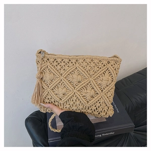 Détail d'une pochette bohème avec tissage en losange évidé et pompon latéral décoratif