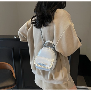 Mini light blue patent leather backpack with lace trim and bow shown on a model back