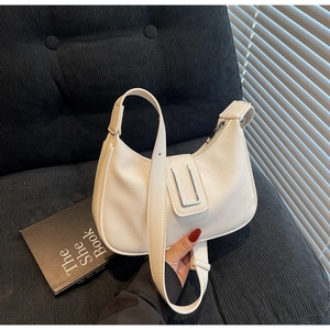 Detail of white lychee leather hobo bag with silver U-shaped metal buckle and wide strap