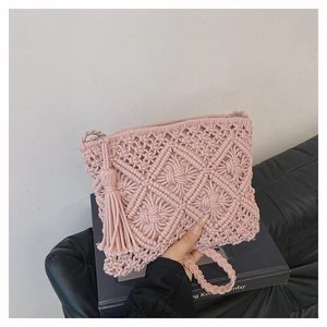 Détail d'un sac à main tissé en macramé rose avec motifs géométriques et franges