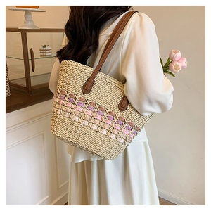 Détail du sac cabas en paille tressée avec rayures crochetées et bandoulière en cuir