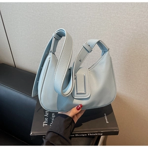 Detail of light blue lychee pattern leather hobo bag with silver U-shaped magnetic buckle