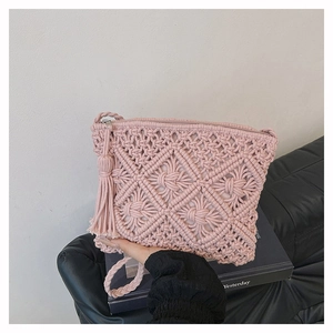 Détail du sac bohème rose tissé main avec motifs d'épis de blé et breloque pompon