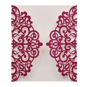 Close-up of laser-cut glitter paper wedding invitation with floral pattern in purple