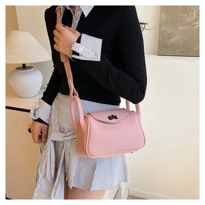 Close-up of pink lychee pattern leather shoulder bag with silver turn-lock buckle