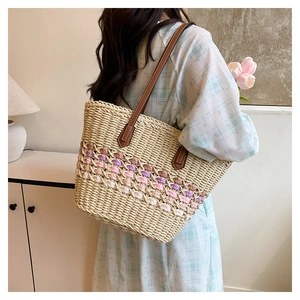 Détail du sac cabas en paille tissée avec motif dégradé et anses en cuir