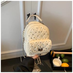 Close-up of beige quilted mini backpack with rhinestone detailing and chain straps