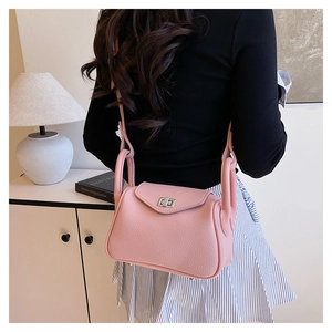 Pink lychee texture crossbody bag featuring silver turn-lock and adjustable strap