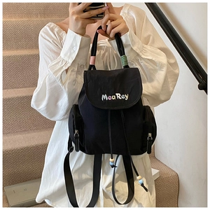 Detail eines schwarzen Nylon-Rucksacks mit MeaRey-Stickerei und bunten Kordelperlen