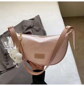 Pink crescent shoulder bag featuring floral jacquard texture and white plush cloud charm