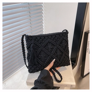 Détail du sac bandoulière tissé noir bohème avec fermeture à franges et motif diamant