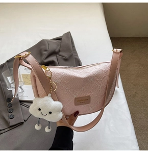 Pink embossed underarm bag with zipper closure and cute white fluffy cloud pendant