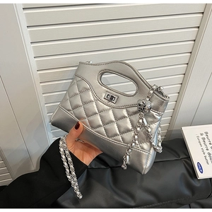Detail of silver quilted handbag with hollow handle and metallic chain strap