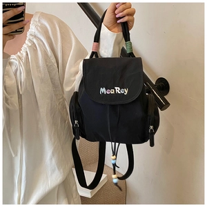 Detail des schwarzen Mini-Rucksacks mit MeaRey-Stickerei und bunten Perlen-Kordelzügen