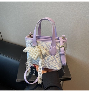 Detail of lavender floral jacquard bucket bag with pearl heart pendant and lace bow