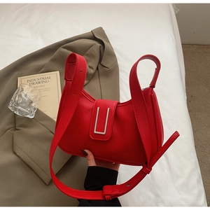 Detail of red lychee pattern leather shoulder bag with stylish U-shaped silver buckle