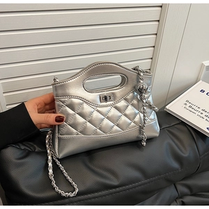 Detail of silver quilted leather bag with metallic finish and metal ball chain