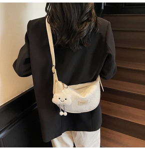 White textured dumpling bag with cute cloud charm and leather brand tag detail