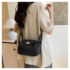 Detail of black lychee grain leather crossbody bag with silver rotating metal buckle