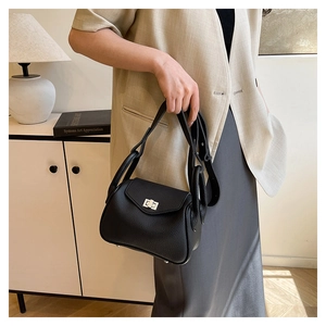 Detail of black pebbled leather texture and silver clasp on the Lindy style shoulder bag