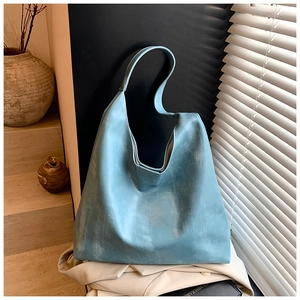 Detail of light blue hobo bag showing vintage wash texture leather in natural sunlight