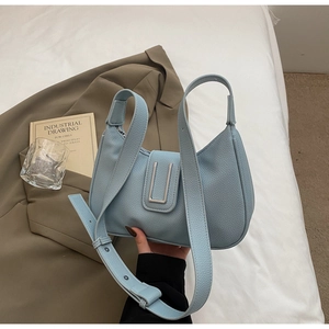 Detailed view of light blue croissant bag with lychee texture and silver U-shaped clasp