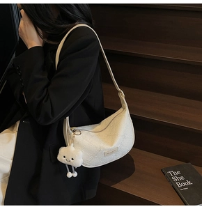 Detail of white moon bag with embossed floral texture and cute cloud plush charm