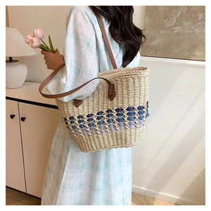 Détail du sac cabas en paille tissée avec dégradé bleu et lanières en cuir