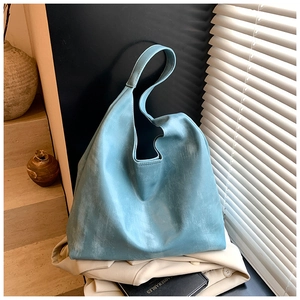 Detail of light blue tote bag with distressed texture on a trench coat background
