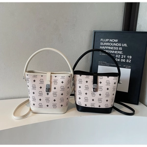 Detailed view of monogram bucket bags with bear patterns and silver hardware accents