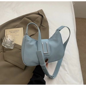 Close-up of sky blue lychee grain leather bag with silver U-shaped metal buckle detail