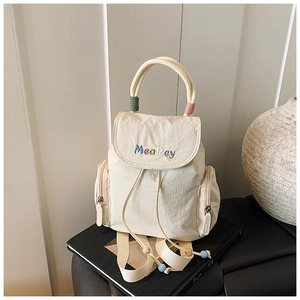 Nahaufnahme des beigen Nylon-Rucksacks mit farbenfroher MeaRey Markenstickerei
