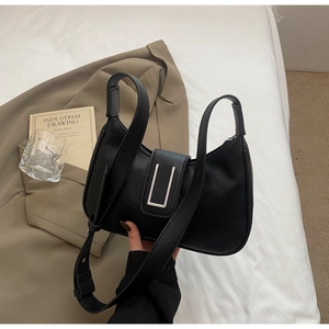 Détail du sac croissant en cuir grainé noir avec une boucle métallique argentée épurée