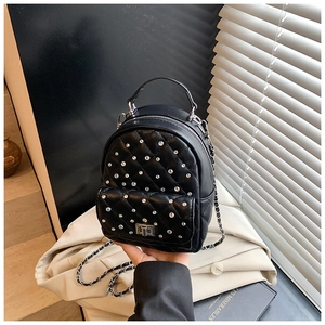 Detail of black quilted mini backpack with sparkling rhinestones and chain strap