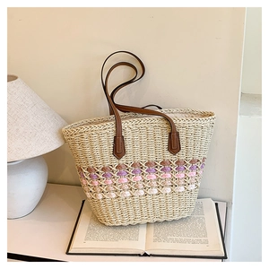 Détail du sac cabas en paille tissé main avec motifs de vagues et anses en cuir